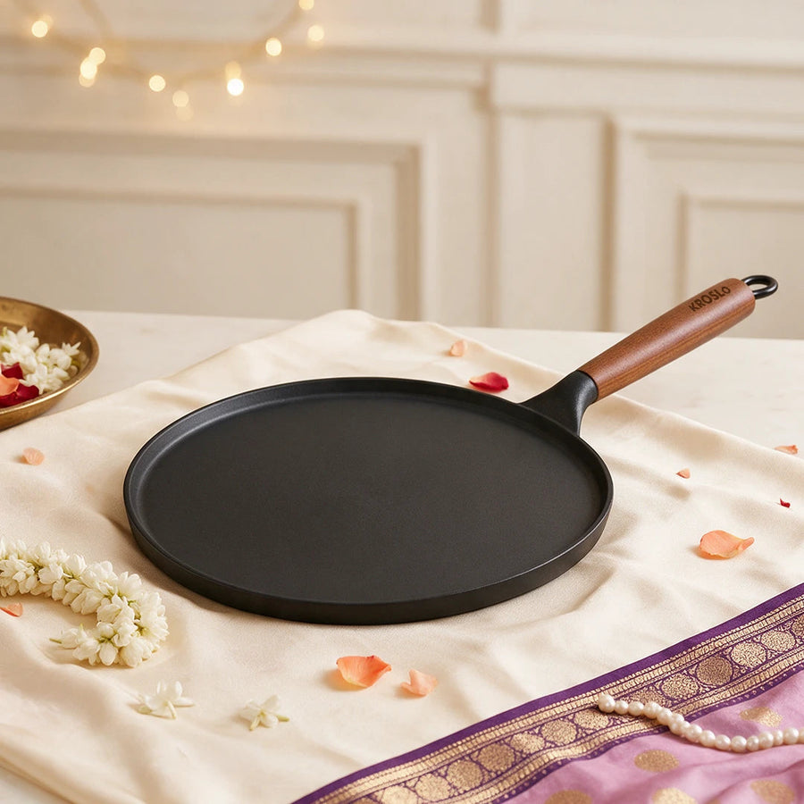 A cast iron dosa tawa on cream silk with jasmine and pearls