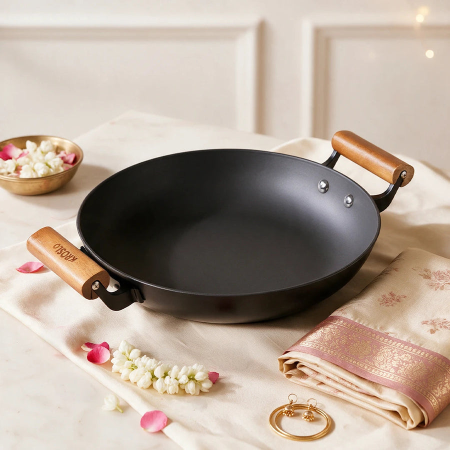 A cast iron shallow kadhai on cream silk with jasmine and a saree border